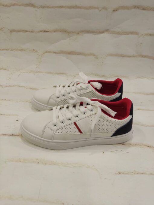 Tenis blancos con suela y cordones del mismo color. Detalles en azul marino y rojo.