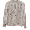 Blusa blanca de chica con flores de colores bordadas, corte holgado, mangas largas abullonadas y cuello en V con borde fruncí