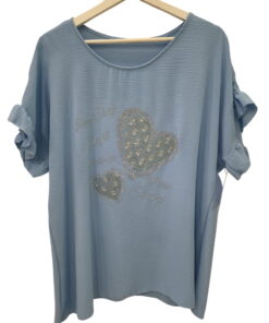 Camiseta de chica en azul claro, tejido con textura arrugada, corte holgado, mangas cortas con nudo, estampado de corazones y