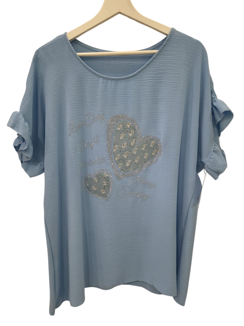 Camiseta de chica en azul claro, tejido con textura arrugada, corte holgado, mangas cortas con nudo, estampado de corazones y