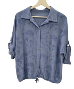 Blusa de manga larga en tono azul celeste oscuro con bordados de paisley, cuello clásico, botones frontales y dobladillo con