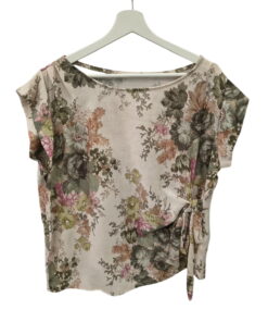 Blusa color crema de manga corta para chica, estampada con flores en tonos verdes, ocres y rosas, corte holgado y nudo decor.