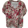 Blusa de fondo marfil con estampado floral en tonos rojos, rosas y verdes, corte holgado, manga corta vuelta y cuello solapa.