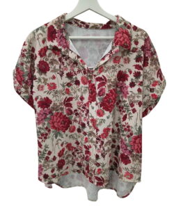 Blusa de fondo marfil con estampado floral en tonos rojos, rosas y verdes, corte holgado, manga corta vuelta y cuello solapa.