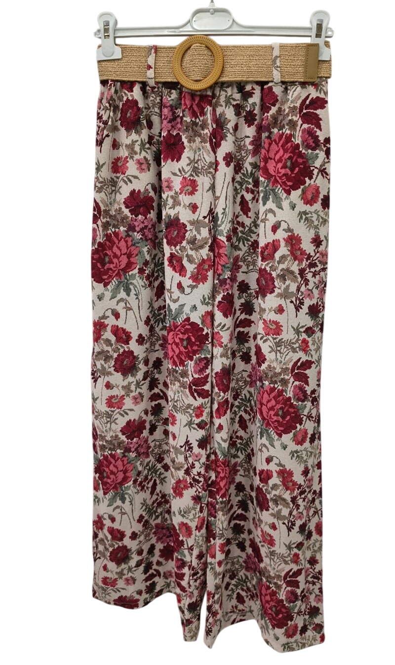Pantalón ancho de chica con estampado floral en tonos rojos y rosas, fondo claro, cinturilla elástica y cinturón de rafia con