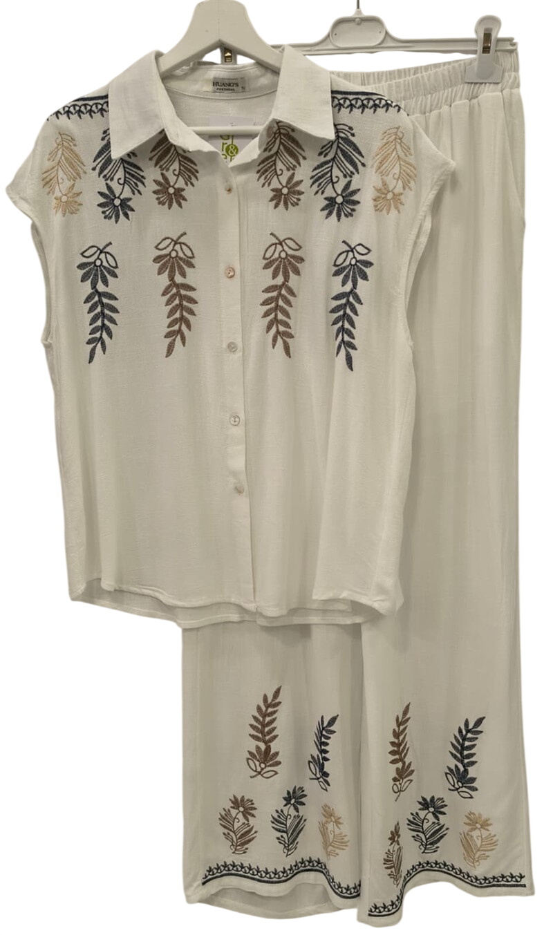 Conjunto de chica en color crema con blusa holgada y pantalón ancho, ambos con bordados florales marrones, azules y dorados