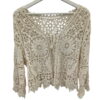Chaqueta de punto calado para chica en tono crudo, con patrones de mandala grandes, cierre de cordón y terminación irregular