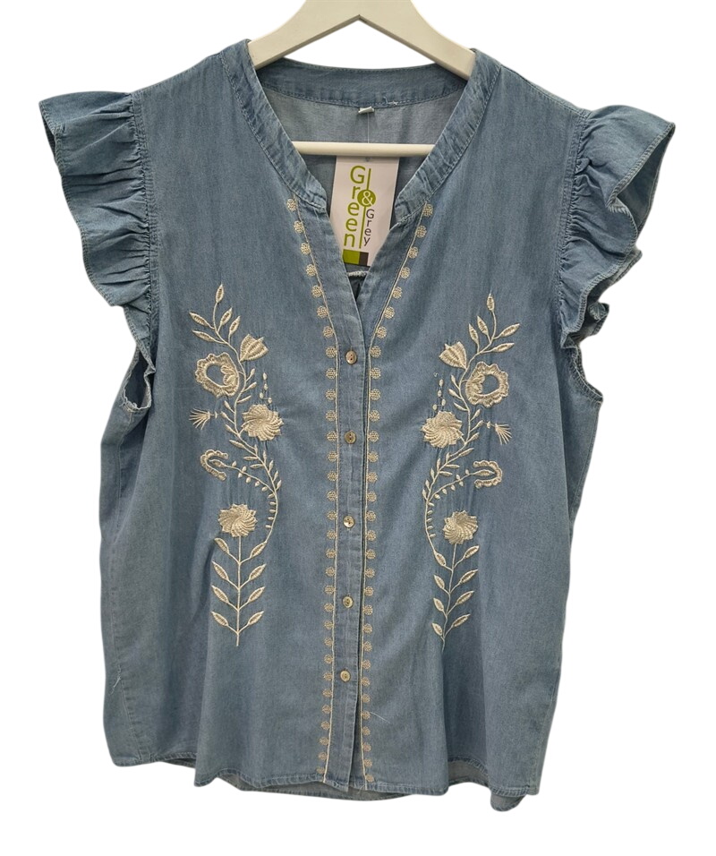 Blusa vaquera sin mangas en azul denim para chica, con bordados florales crema a ambos lados y volantes decorativos en las sI