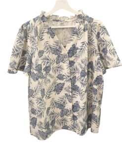 Camisa de chica con estampado tropical de hojas de palma azul, fondo claro, manga corta, algodón ligero. Corte recto y cuello