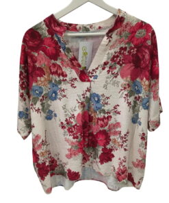 Blusa oversize de manga corta para chica, fondo claro con estampado floral grande en rojo, azul y verdes, cuello mao con escu
