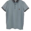 Polo de chico en azul grisáceo liso, manga corta, corte recto, cuello polo negro con detalles blancos y pequeño escudo bordad