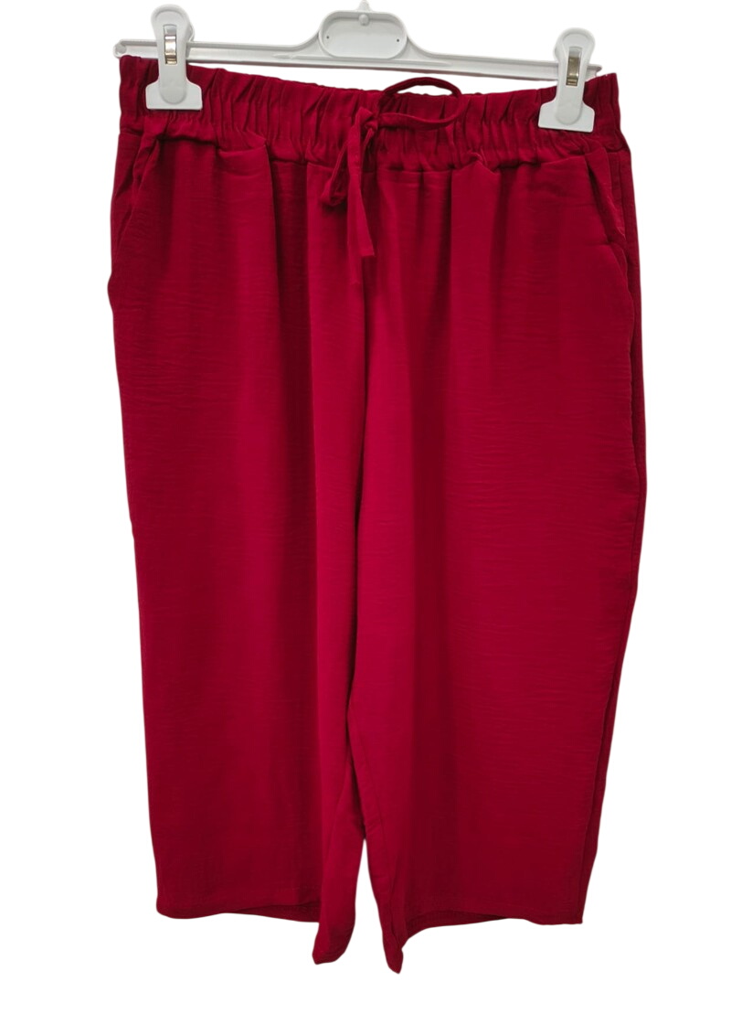 Pantalón estilo pirata corto de chica en color rojo intenso, corte flojo a media pantorrilla, cinturilla elástica con cordón
