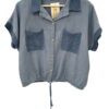Camisa azul grisáceo para chica con cuello de ganchillo oscuro, mangas cortas también bordeadas en ganchillo, bolsillos front
