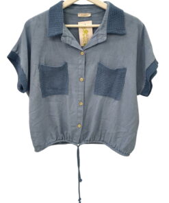 Camisa azul grisáceo para chica con cuello de ganchillo oscuro, mangas cortas también bordeadas en ganchillo, bolsillos front