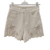 Short vaquero de chica en denim blanco crema, corte recto, dobladillo ondulado y bordado de palmeras tropicales en hilo marr