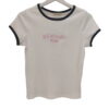 Camiseta de canalé para chica en tono blanco o crema, manga corta, cuello redondo ribeteado en contraste oscuro y logo New |