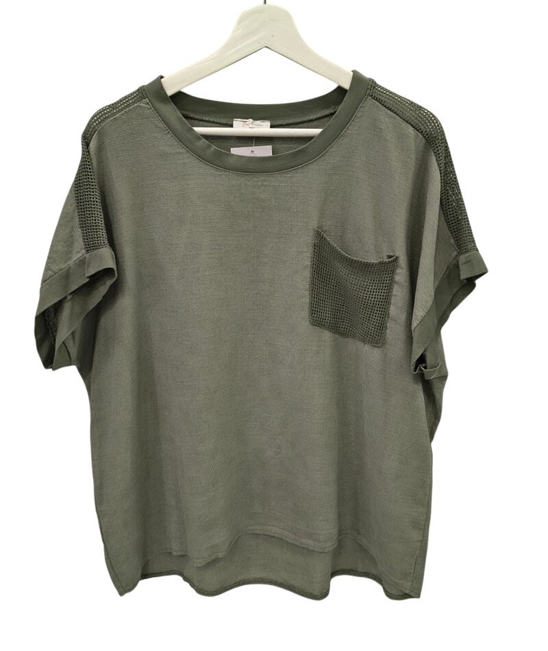 Blusa de chica en tejido verde oliva, corte holgado, con ganchillo en hombros y bolsillo en el pecho. Detalle de dobladillo y