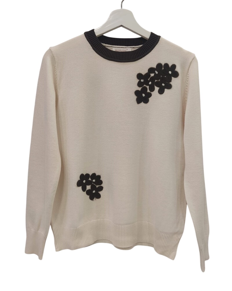Jersey bicolor de mujer en color marfil con cuello negro y aplicaciones de flores de felpa negras, mangas largas y ajuste hol