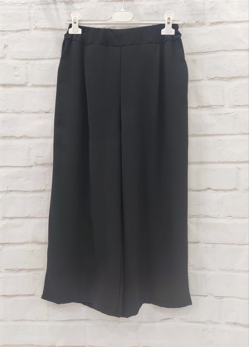Pantalón culotte de verano para chica en color negro, corte amplio y largo midi, con cintura elástica y bolsillos al bies, en