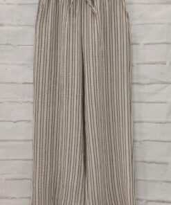 Pantalón flojo de chica en tejido fino con rayas verticales blancas y fondo oscuro, cintura elástica y corte amplio, estilo l