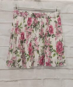 Minifalda plisada para chica en tejido poliéster con estampado de flores rosas sobre fondo claro, diseño corto y juvenil, con