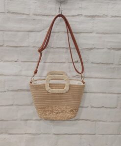 Bolso tipo capazo mediano de rafia natural en tono neutro, base trenzada, parte superior lisa, asas cortas trenzadas y asa de